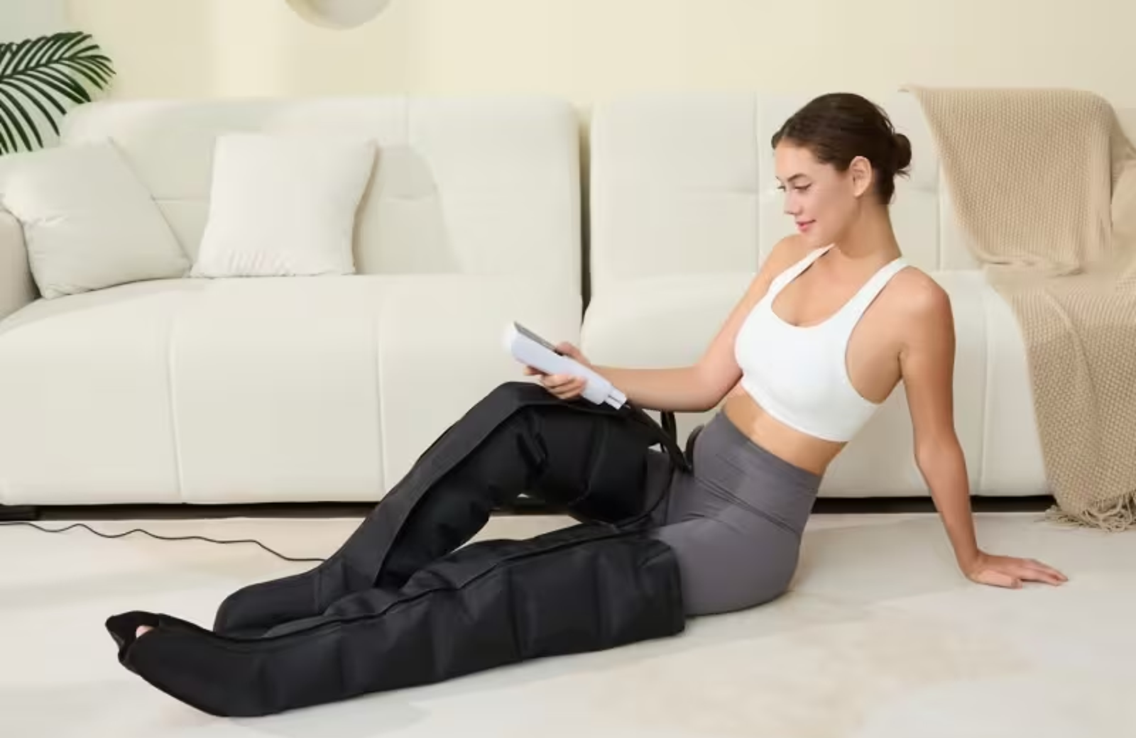 Woman using RecoverPro compression boots at home during a recovery session